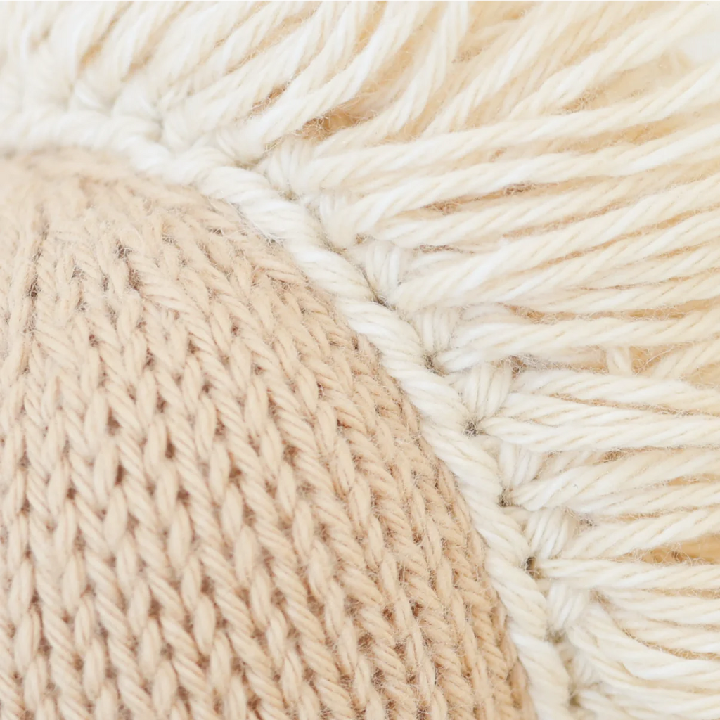 Close-up of the Cuddle + Kind Baby Pony, highlighting its thick knit stitches and cream-colored fringed threads made from Peruvian cotton yarn, showcasing the plush texture and intricate handcrafted detail.