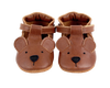 A pair of Donsje Baby Bear Shoes made from premium leather, designed to look like bears, featuring rounded ears, stitched eyes, and black noses with a Velcro fastening strap, isolated on a black background.
