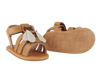 A pair of Donsje Baby Bee Shoes displayed against a transparent background, featuring a premium leather base with a beige and white butterfly decoration on the top strap.