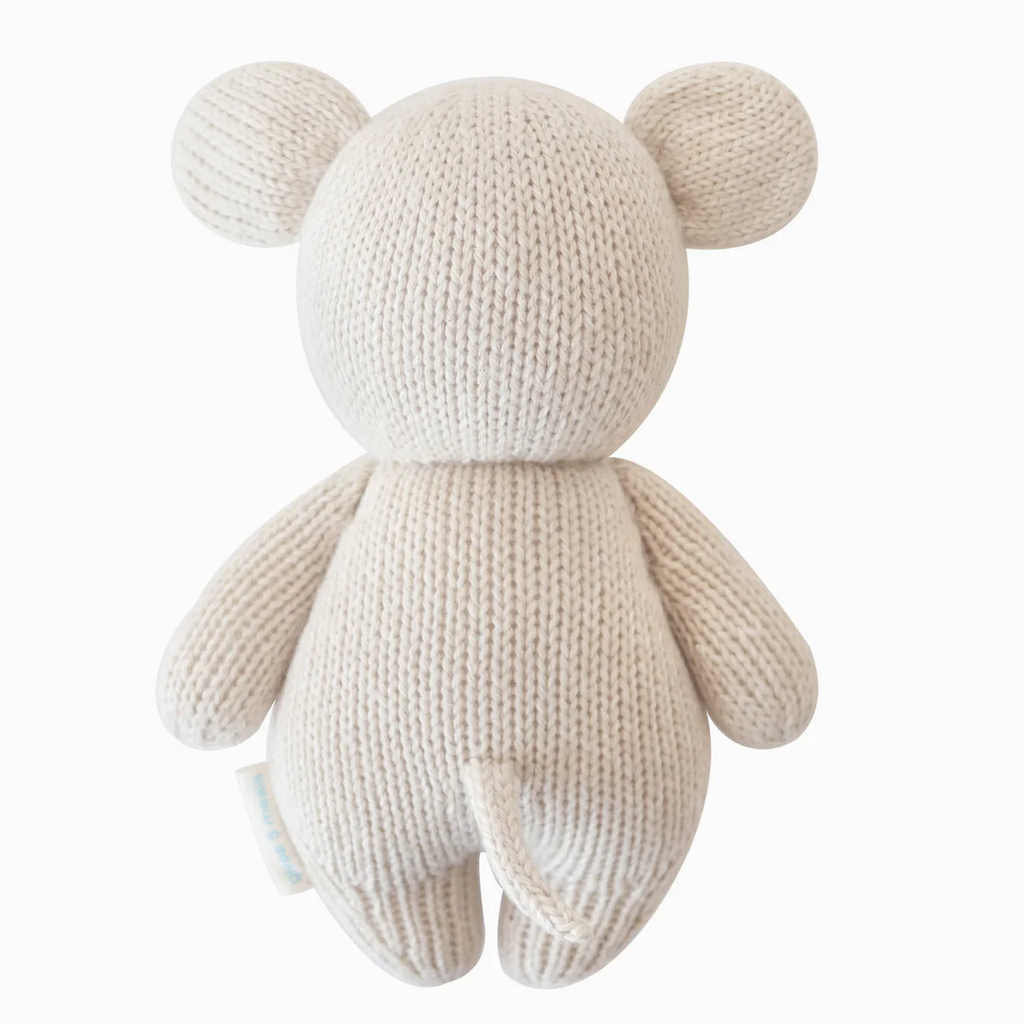 The Cuddle + Kind Baby Mouse plush toy is shown from the back, hand-knit from soft Peruvian cotton yarn with round ears, arms, legs, and a small tail.