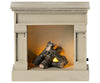 A small, decorative electric fireplace with a realistic flame effect, featuring imitation logs in a Maileg Farmhouse - Fully Furnished mantel design, isolated on a white background.