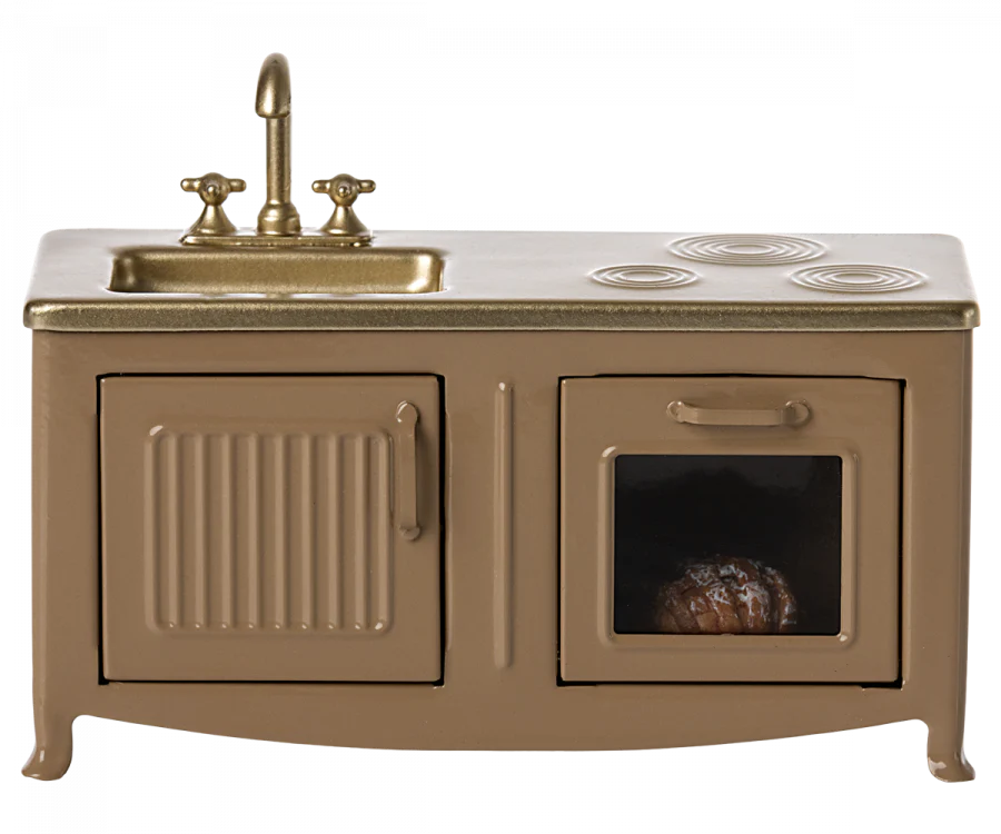 A Maileg Farmhouse - Fully Furnished featuring a beige finish with a built-in sink, faucet, and stovetop, and an open oven door revealing a roast chicken inside.