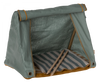 A small fabric "Maileg Happy Camper Tent" in olive green, featuring roll-up shades and a striped cushion inside, set against a transparent background.