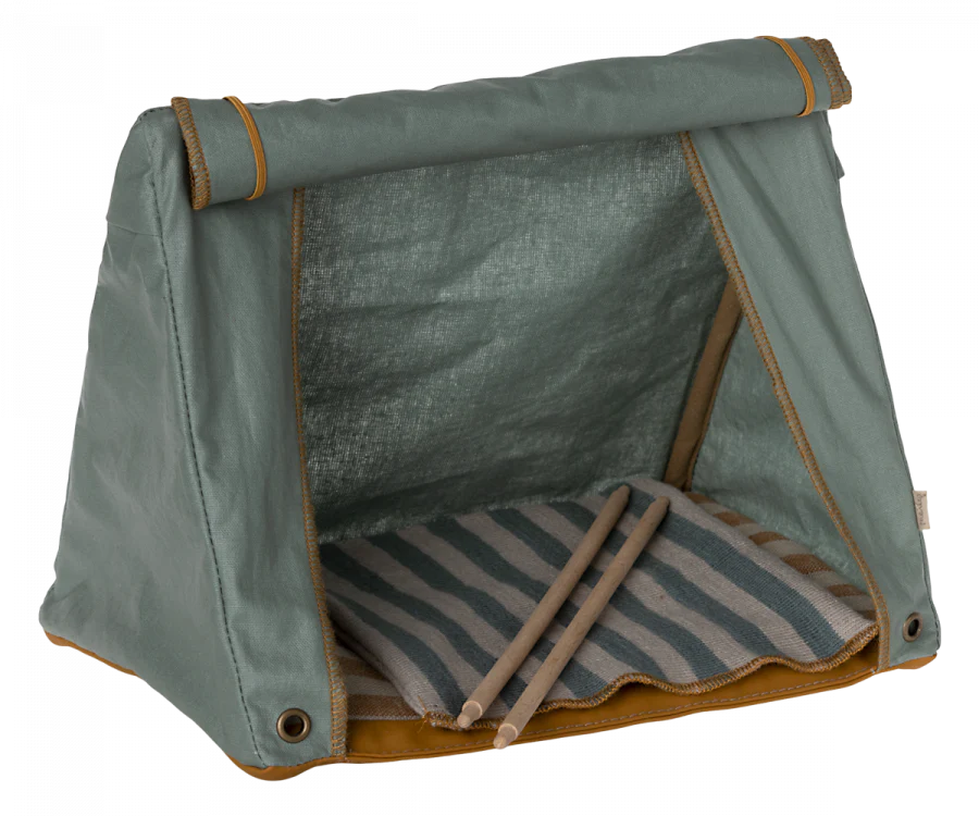 A small fabric "Maileg Happy Camper Tent" in olive green, featuring roll-up shades and a striped cushion inside, set against a transparent background.