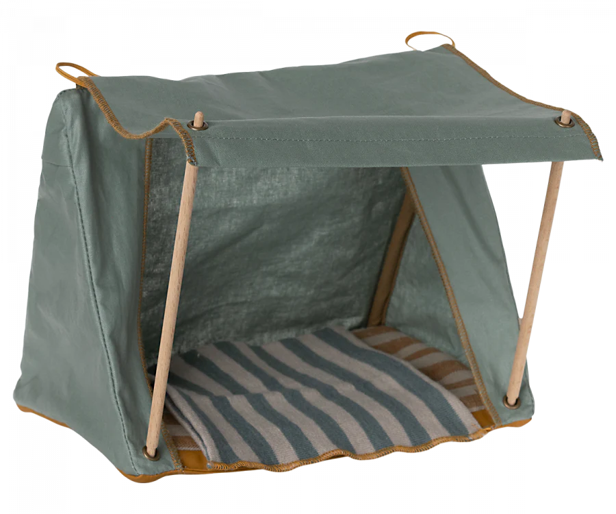 A green canvas Maileg Happy Camper Tent for pets with a cozy striped cushion inside. The tent is supported by thin wooden poles, featuring an open front and a flat top.