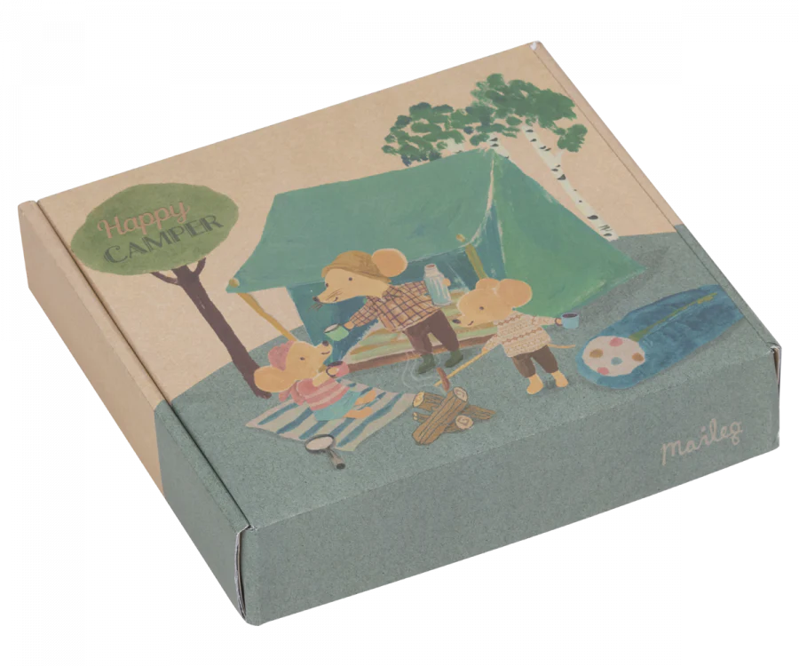 Illustrated cardboard box depicting a cozy camping scene with anthropomorphic mice, featuring a Maileg Happy Camper Tent, campfire, and river. The box is labeled "Happy Camper.