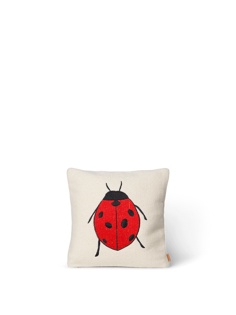The Ferm Living Forest Embroidered Cushion - Ladybird is a square white organic cotton cushion with a large red and black ladybird embroidered on the front.