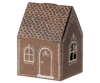 A small, brown paper Maileg Santa Mouse designed to look like a gingerbread house. It features white icing-like decorations, including rooftop details, window frames, and a decorative door. The house has a simple and whimsical design perfect for Christmas night.