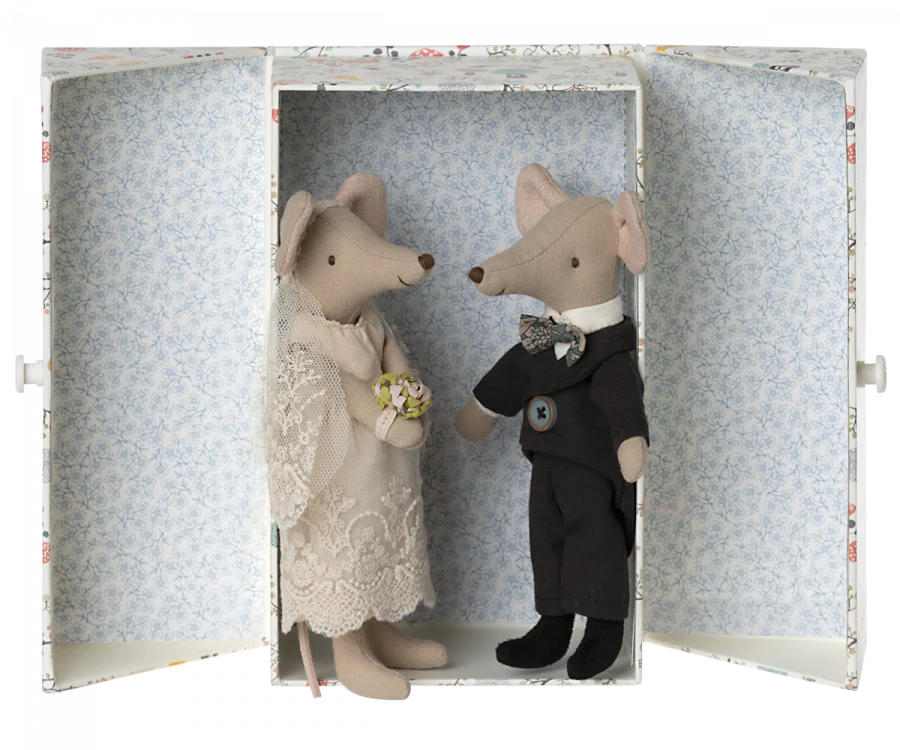 Two Maileg Wedding Mice Couple in Box figurines dressed as a bride and groom inside a box with floral wallpaper. The bride holds a tiny bouquet, and the groom wears a suit with a boutonniere.