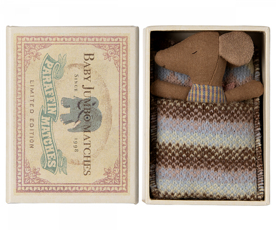 A small plush Maileg Sleepy Wakey Baby Mouse in Matchbox - Rose soft toy in a knitted sweater, snugly placed inside a vintage matchbox bed labeled "baby lucas safety matches, limited edition 1989.