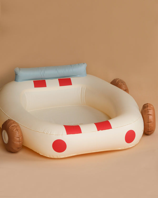 The Inflatable Car Pool is shaped like a car with blue seat cushion and red and white racing stripes, set against a plain beige background. This pool is made from durable PVC for enhanced children safety.