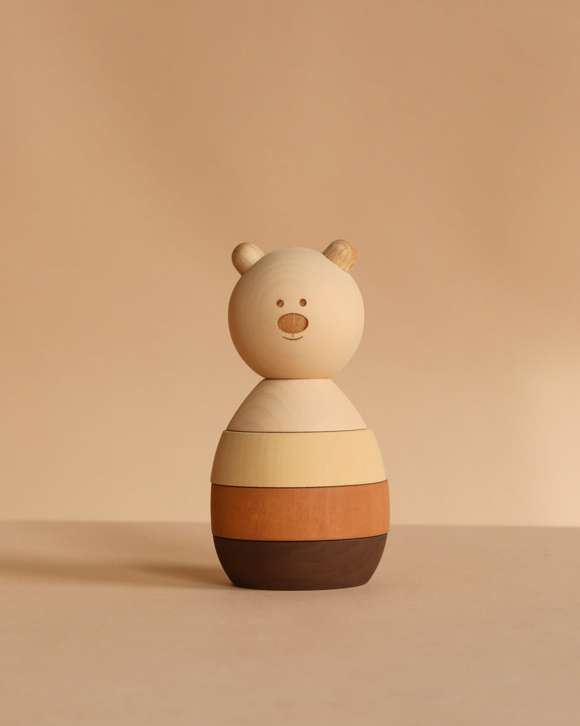 The Sabo Concept Bear Stacker - Beige is a charming wooden toy with three colorful rings that stack to form a bear’s body, perfect for playful stacking games.