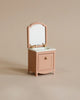 A small, elegant pink vanity from the Maileg Spa Starter Set collection, featuring a single drawer and cabinet with a matching rectangular mirror, set against a neutral beige background.