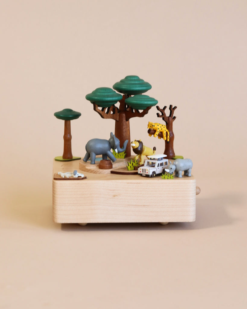 Wooden music box with a tree in the middle with African animals. A small wooden jeep going around the music box.