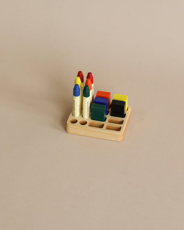 A Crayon Tray For Stockmar - 8 x 8 Slots featuring six colorful ink pads and five Stockmar sticks neatly arranged on a beige background.