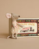 A Maileg Little Sister mouse figure in a polka dot dress stands next to a vintage matchbox labeled "mouse race" featuring a mouse driving a car.