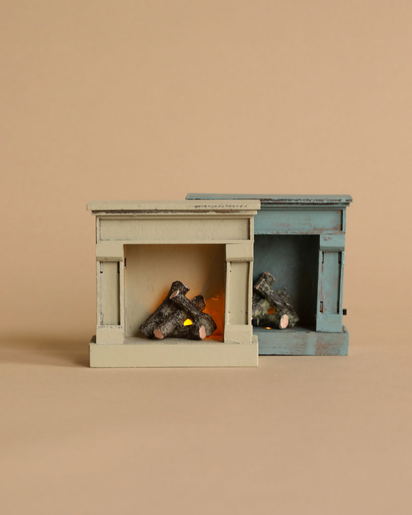 Off white fire place in front of blue fire place. Beige background.