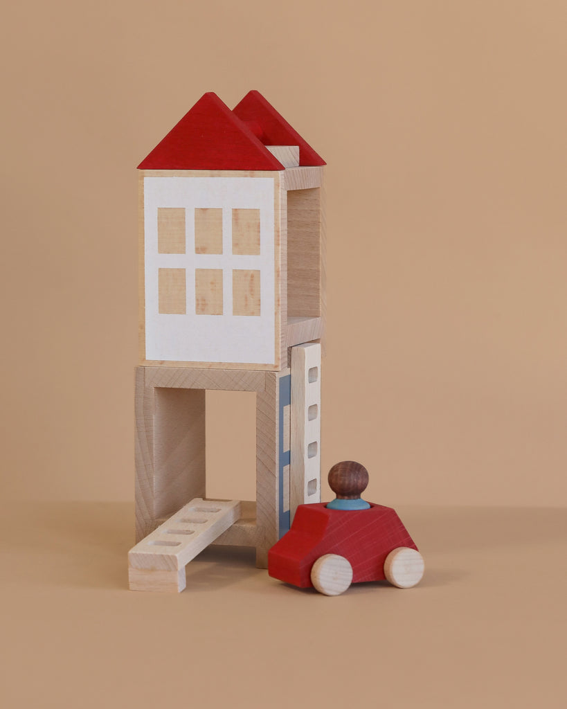 The Lubulona Lubu Town Summerville Set features a wooden toy house with a red roof, white windows, and an open lower level. A small red car with a driver is parked in front—perfect for eco-friendly toy collections.