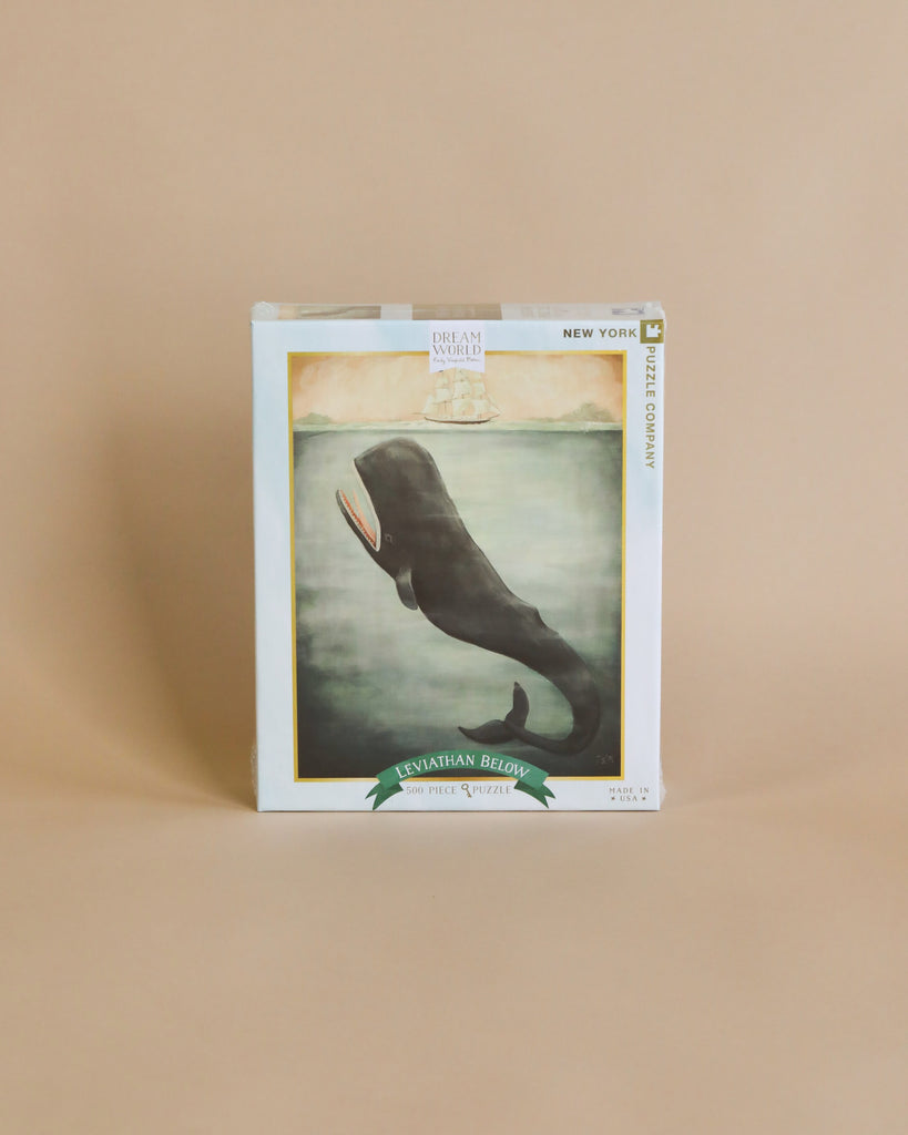 A Emily Winfield Martin, Leviathan Below Puzzle - 500 Piece of "Leviathan Below" by Dream Whaled, displayed against a plain beige background. The cover features an artwork of a whale's tail submerged in foggy water, resembling.