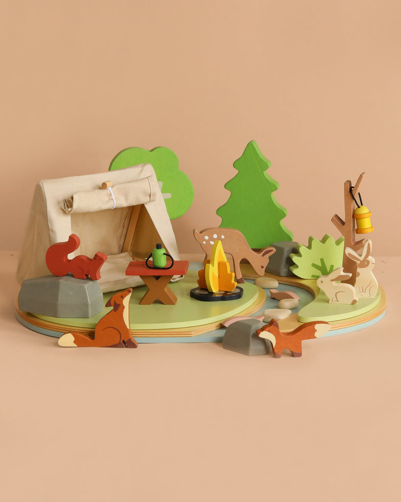 The Wildlife Camping Playset is a wooden toy set with a tent, campfire, table, trees, rocks, stream, and forest animals like a fox and owl—ideal for imaginative play or as an addition to any dolls house adventure.