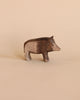 A handcrafted Ostheimer Wild Boar figurine, displayed against a soft beige background, featuring detailed textures and a lifelike pose.