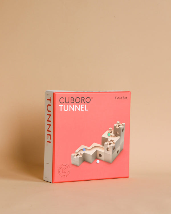 A Cuboro Tunnel Marble Run Extra Set box with a beige background. The box is pink with a white and gray block structure displayed in front, demonstrating one of the possible constructions from this educational toy.