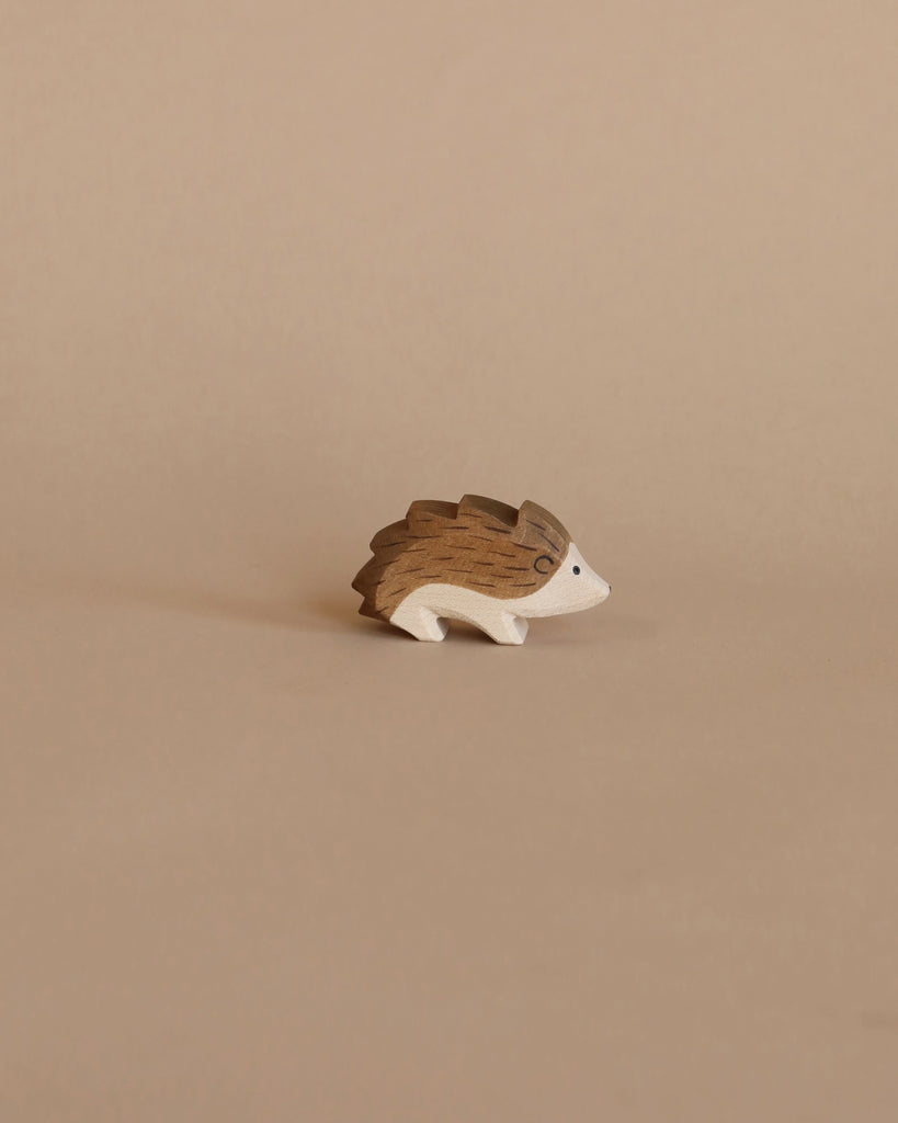 A handcrafted Ostheimer Hedgehog figurine on a plain beige background, featuring intricate grain patterns and carved details.