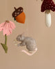 A Handmade Mobile - Forest Friends - Final Sale featuring a grey mouse with a flower, suspended along with felt mushrooms, an acorn, and a flower, against a neutral background.