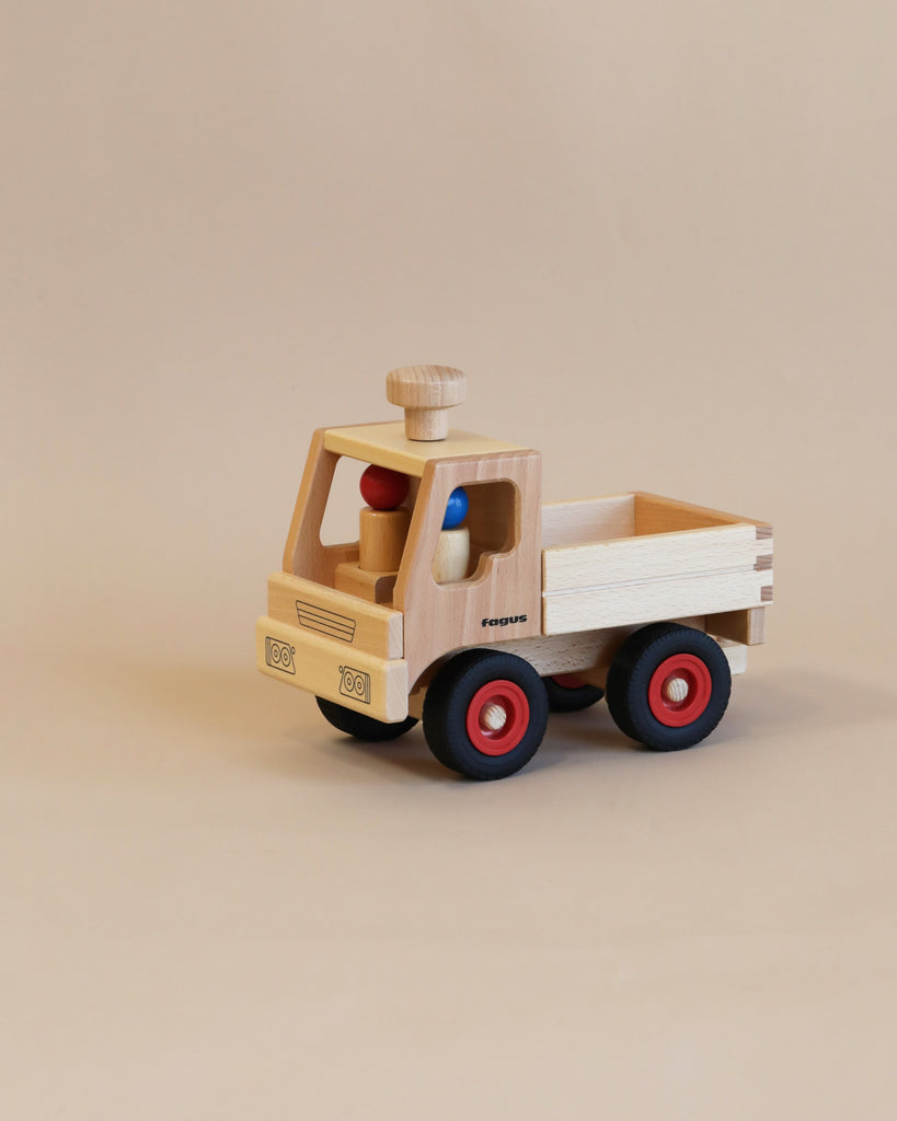A handcrafted Fagus Wooden Unimog Truck with red wheels, a colorful interior, and the word "equus" on the front, displayed on a plain beige background.
