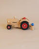 Sentence with Product Name: A Fagus Wooden Tractor with the word "fagus" printed on it, featuring a movable steering knob and colored wheels, displayed against a neutral background.