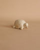 A small Handmade Tiny Wooden Forest Animals - Turtle figurine with subtle cracks displayed on a plain beige background.