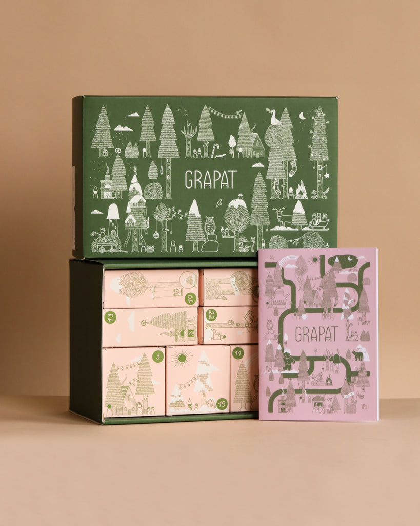 A green box with whimsical white illustrations labeled "Grapat Quiet Time Advent Calendar 2025" sits atop two pastel boxes and a purple booklet, showcasing limited edition, nature-inspired packaging against a beige background.