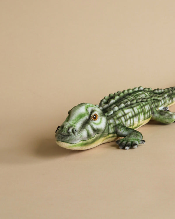 A realistic plush model of an Alligator Stuffed Animal resting on a plain beige background.