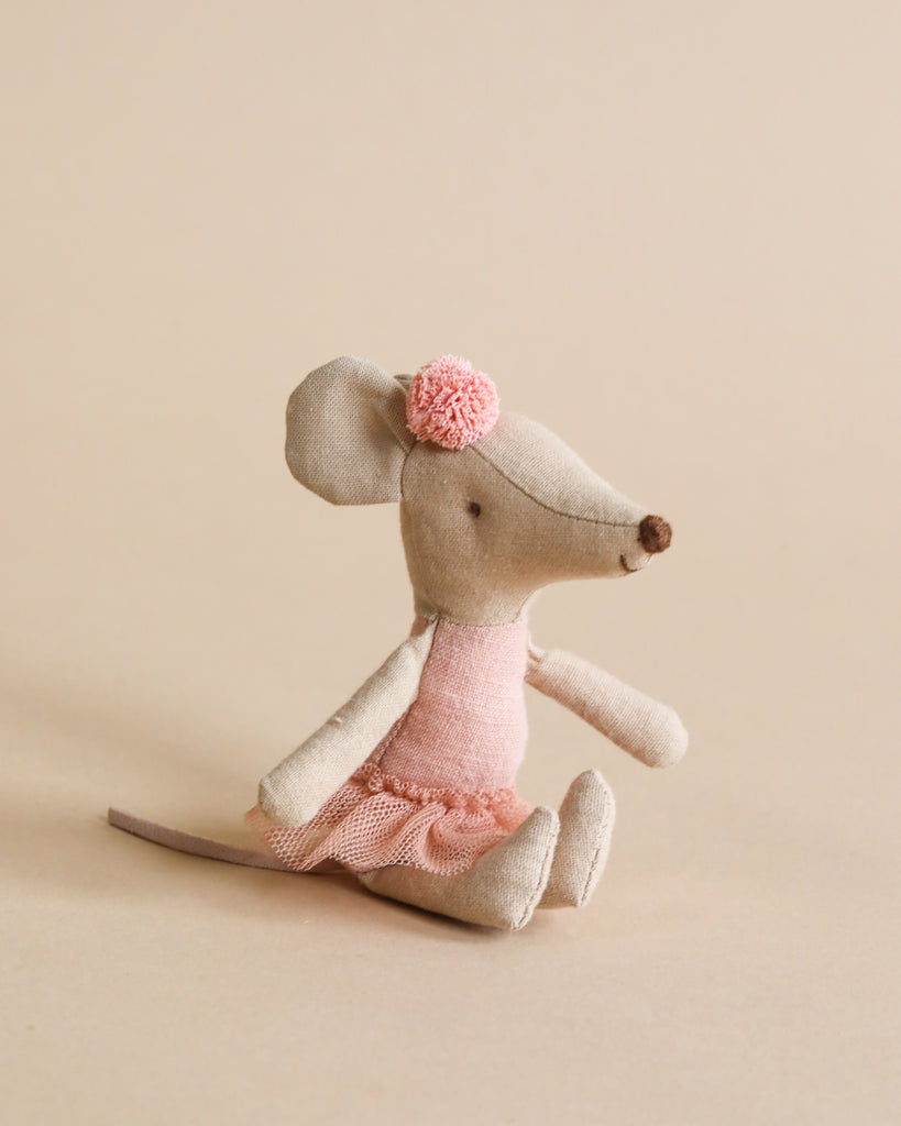A Maileg Ballerina Mouse - Big Sister wearing a rose tutu shirt and a bow, sitting against a plain beige background.