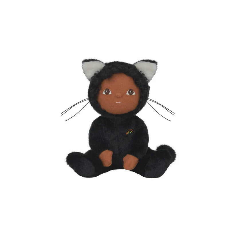 The Olli Ella Dinky Dinkum Doll - Carson Cat - Black is a plush doll with brown skin, dressed in a soft black cat costume with pointy-eared hood and rainbow detail on the chest, featuring a sweet expression.