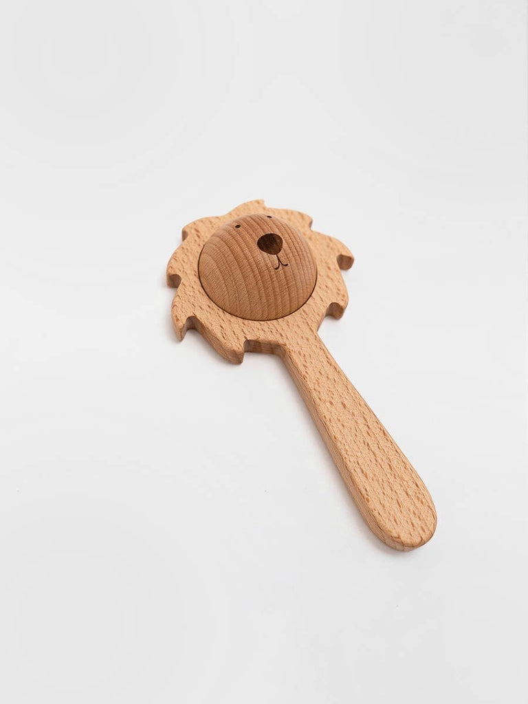 The Sabo Concept Lion Rattle - Natural is a wooden baby toy shaped like a lion's head with a mane and smooth handle, crafted from natural materials and shown on a plain white background.