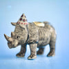A small heirloom-quality Rhino Cake Topper, set against a soft blue background.