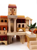 A detailed Sabo Concept Italian Ancient City Blocks set, featuring various structures such as buildings, arches, and columns reminiscent of Italian seaside towns, assembled in a creative layout with a small wooden plant decoration to the side.