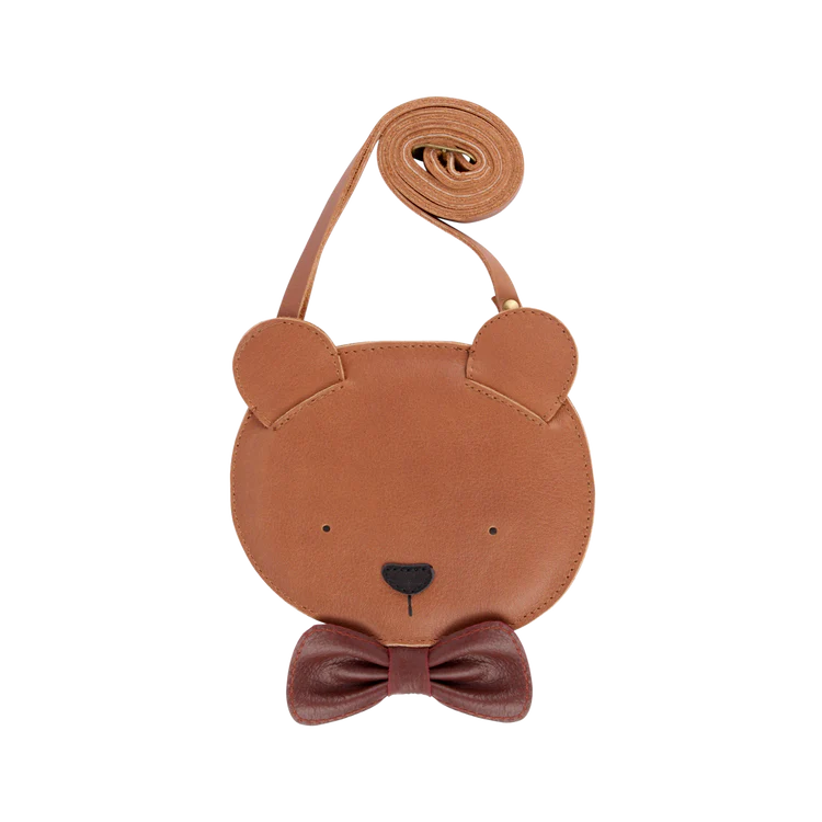 A small, circular Donsje Britta Exclusive Purse | Winter Bear designed to look like a grizzly bear's face, featuring ears and a bow tie, with an adjustable rolled leather strap, isolated on a white background.