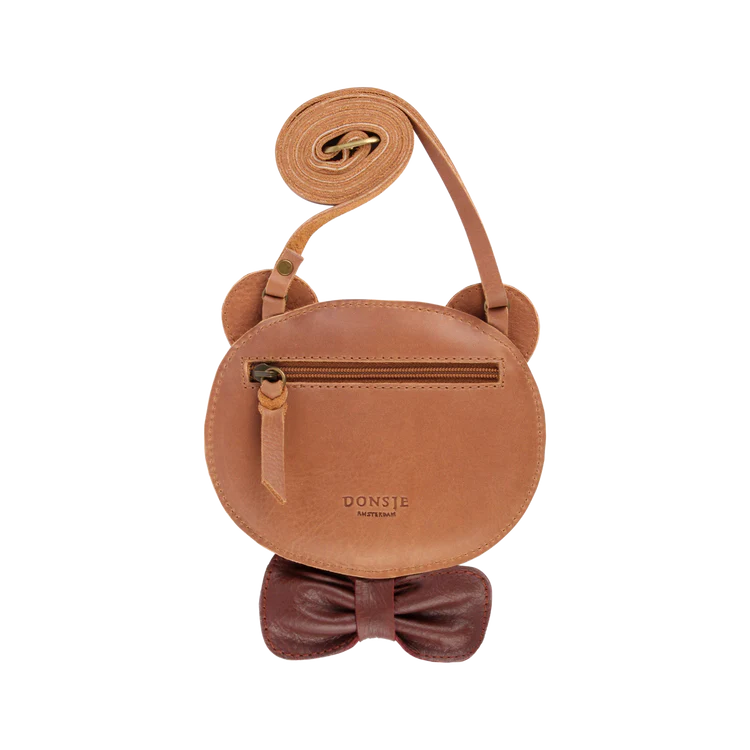 A round Donsje Britta Exclusive Purse | Winter Bear with a rolled leather strap, featuring a small zipper compartment and embossed brand name "Donsje." The purse is designed to resemble a cute animal with ears.