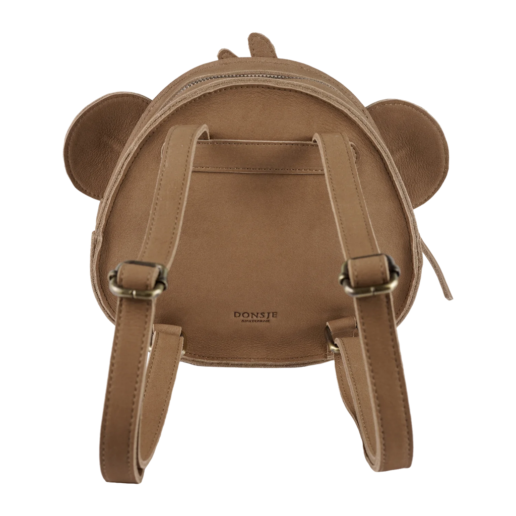 The Donsje Leather Kapi Backpack - Monkey is a kids' backpack shaped like a monkey's face, made from premium leather with round ears, two adjustable shoulder straps, and features the brand's logo near the bottom center of the back.