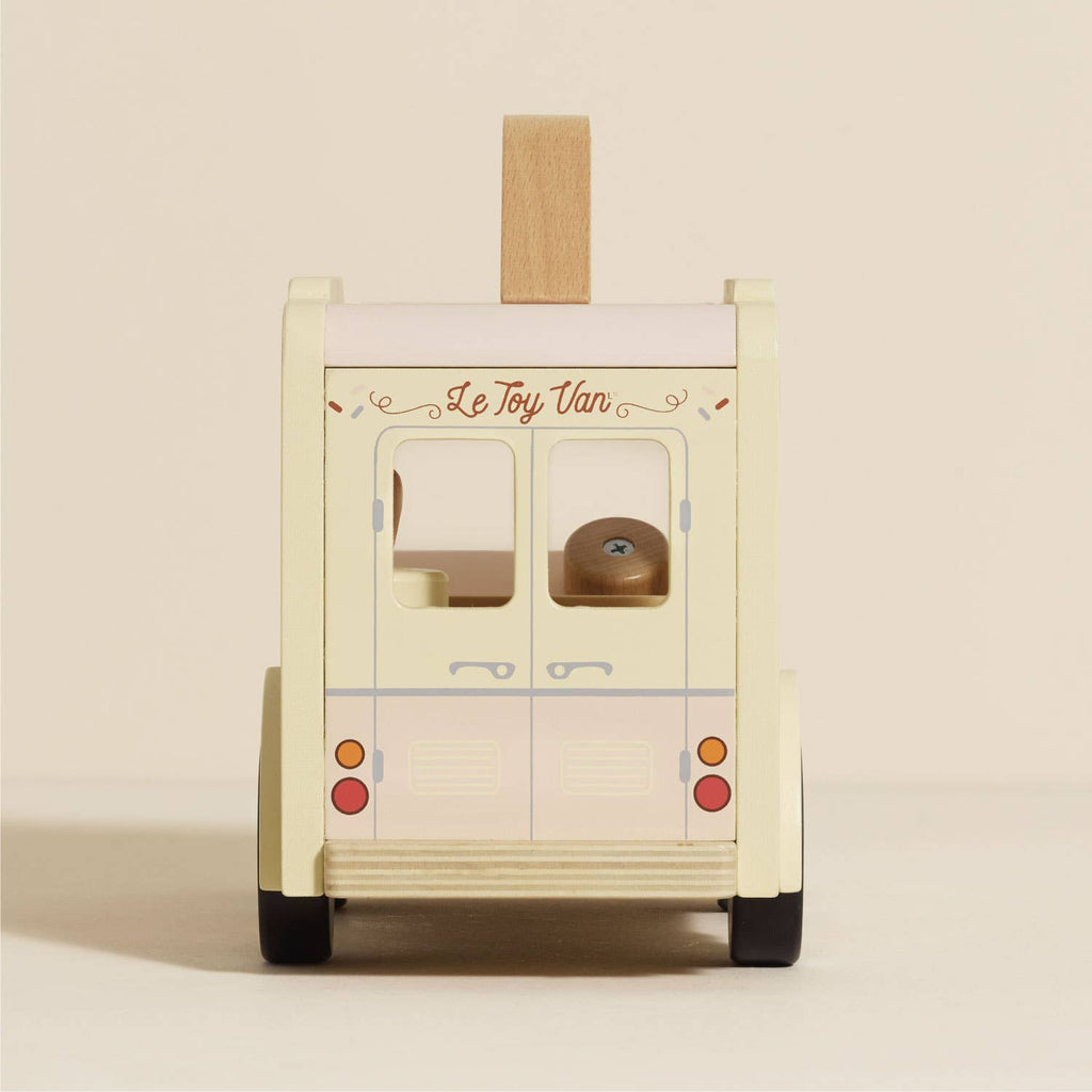The Wooden Ice Cream Van features a vintage design with cream and pastel pink colors, red rear lights, and "Le Toy Van" above the doors.
