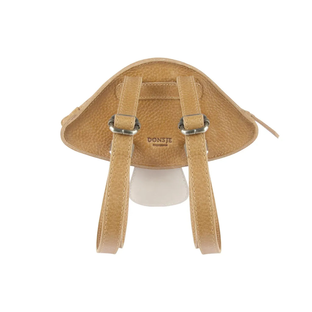 A tan-colored Donsje Tum Backpack - Mushroom designed to resemble an animal's face, featuring two straps and a logo reading "donsje" at the top center, displayed against a white background.