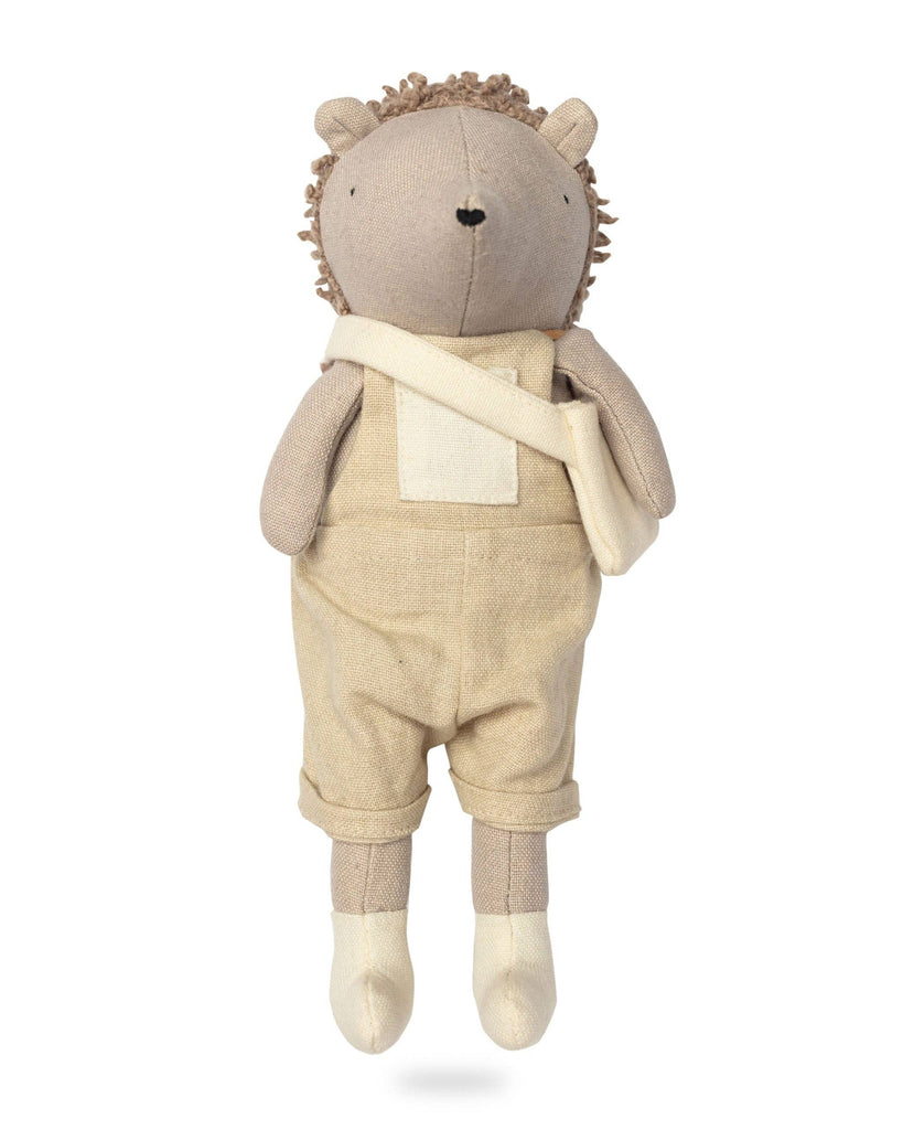 Heather The Hedgehog enchants with her charm, donning beige overalls and a shoulder bag. Her light brown fur contrasts with darker textured hair. Standing upright against a white background, she's prepared for garden adventures or cozy cuddles.