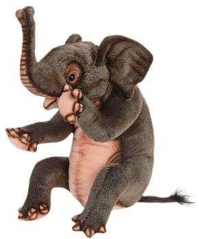 The Elephant Calf Sitting Stuffed Animal by HANSA features textured gray fur, large ears, a raised trunk, a light pink belly, and hand-sewn details on the eyes, toes, and tail. The plush sits upright against a white background.
