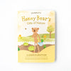 A children's book titled "Slumberkins Honey Bear Kin + Lesson Book On Gratitude" featuring an illustration of a bear engaging in imaginative play in a peaceful outdoor setting on the cover.