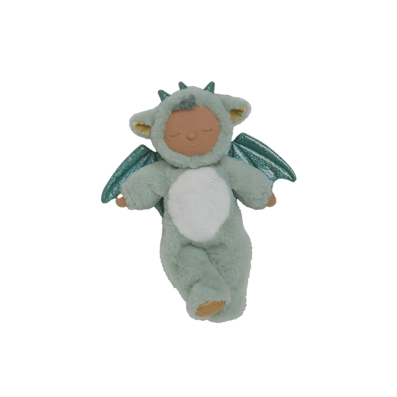 The Olli Ella Cozy Dinkum Dragon - Ash - Green is a weighted plush doll in a soft green recycled dragon costume with a white belly, sparkly wings, and hood with horns and ears. Features closed eyes and a peaceful expression.