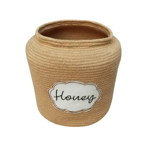 A beige rope-wrapped Basket Honey Pot with a white label featuring the word "honey" written in black cursive, set against a plain background.