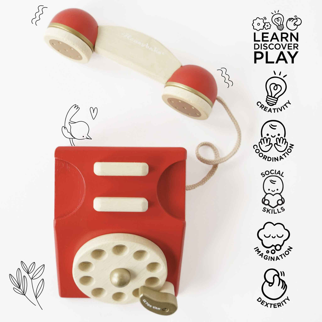 The Vintage Wooden Telephone is a red and cream toy phone featuring “Learn, Discover, Play” and icons for creativity, coordination, social skills, imagination, and dexterity on a white background with playful doodles.