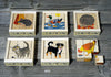 Nine piece farm animal wooden block puzzle on a gray table, each depicting a different animal: a mouse, duck, hedgehog, cat, dog, and rooster, placed in separate compartments.